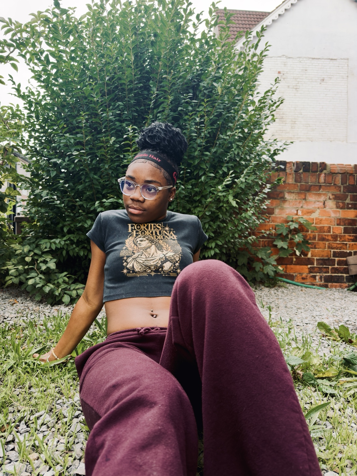 MERAD campaign: graphic crop top styled with burgundy trousers outdoors